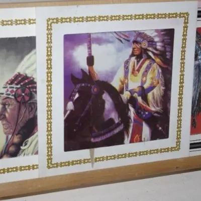 Set of three vintage Native American-themed art prints displayed on a wooden stand, featuring detailed portraits and traditional regalia...
