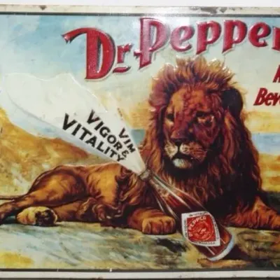 Vintage embossed metal Dr. Pepper advertisement sign featuring a lion and a soda bottle with the slogan 'King of Beverages'.