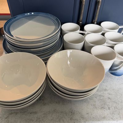 Sale Photo Thumbnail #7: Contemporary blue and white ceramic dinnerware set, including stacks of plates, bowls, and matching coffee mugs.