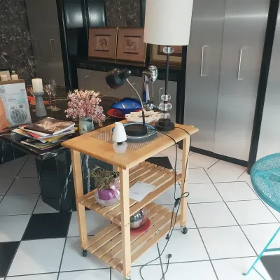 Sale Photo Thumbnail #4: Natural pine three-tier rolling kitchen cart holding various table lamps and decor, alongside a modern black table lamp with a stacked acrylic sphere stem.