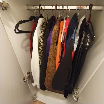 Sale Photo Thumbnail #22: Assorted modern women's clothing, including jackets, sweaters, and tops in various patterns and colors, hanging inside a white wardrobe.