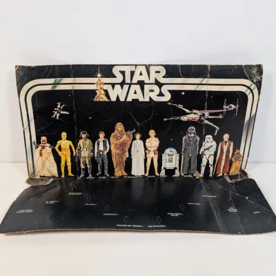 Sale Photo Thumbnail #49: Vintage 1978 Kenner Star Wars Early Bird Certificate cardboard display stand featuring original character graphics, showing visible wear and creasing.