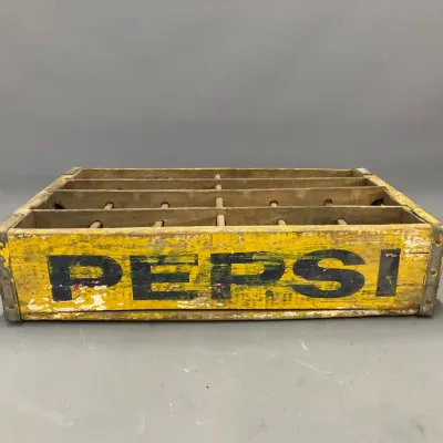 Sale Photo Thumbnail #292: Vintage yellow Pepsi wooden soda crate featuring black lettering, interior dividers, and metal corner reinforcements showing authentic age-related wear.