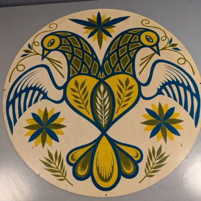 Sale Photo Thumbnail #334: Vintage Pennsylvania Dutch hex sign featuring a stylized two-headed bird and floral motifs in yellow, green, and blue.