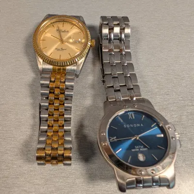 Sale Photo Thumbnail #144: Pair of men's wristwatches, including a DuFonte by Lucien Piccard two-tone quartz watch and a Sonoma stainless steel watch with a blue dial.