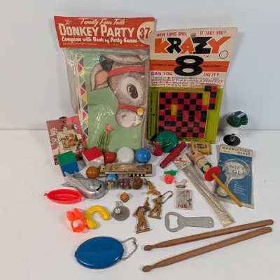 Sale Photo Thumbnail #388: Collection of vintage novelty toys and games, including a packaged Donkey Party game, Krazy 8 checkerboard puzzle, plastic figures, and small knick-knacks.