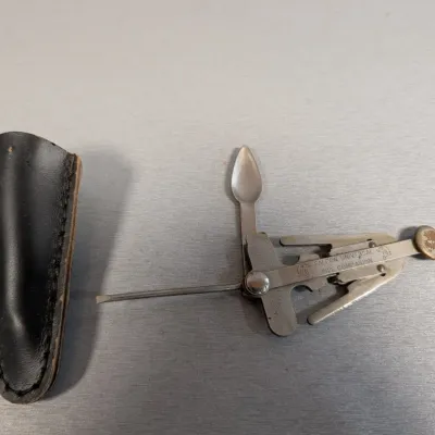 Sale Photo Thumbnail #439: Vintage Falcon Universal Pipe Companion multi-tool with its original black leather sheath.