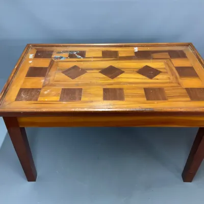 Sale Photo Thumbnail #104: Vintage wood coffee table featuring a geometric marquetry inlay top with diamond and check motifs, showing some surface wear and paint marks.