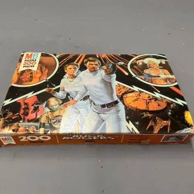 Sale Photo Thumbnail #210: Vintage 1979 Milton Bradley Buck Rogers 200-piece jigsaw puzzle in its original box, showing light shelf wear.