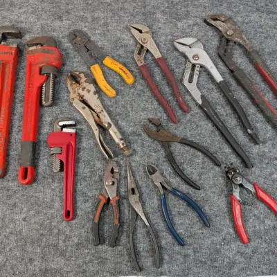 Sale Photo Thumbnail #90: Assorted collection of hand tools including pipe wrenches, locking pliers, slip-joint pliers, needle-nose pliers, and wire cutters.