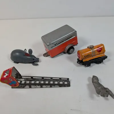 Sale Photo Thumbnail #415: Collection of vintage tin litho and die-cast toys, including a Shell tanker car, a Big G Hauling Company trailer, a wind-up mouse, and a toy ladder.