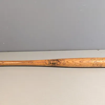 Sale Photo Thumbnail #19: Vintage Louisville Slugger wooden baseball bat featuring a Ralph Kiner signature stamp and Batting Champion branding.