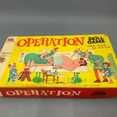 Sale Photo Thumbnail #114: Vintage Milton Bradley Operation board game in its original box, copyright 1965. The box shows minor shelf wear and aging appropriate for its era.