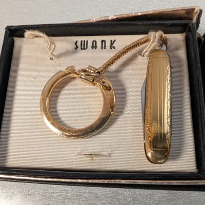 Sale Photo Thumbnail #377: Vintage Swank gold-tone keychain featuring a small fold-out pocket knife, housed in its original display box.