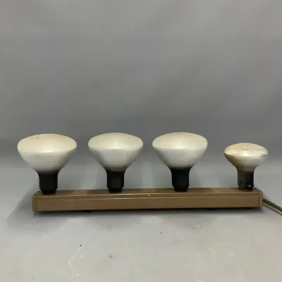 Sale Photo Thumbnail #83: Vintage four-light photographic movie light bar featuring large flood bulbs on a metallic bronze base with attached power cord.