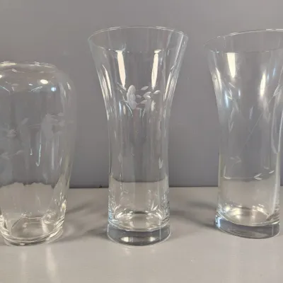 Sale Photo Thumbnail #121: Trio of clear glass flower vases featuring delicate etched floral patterns.