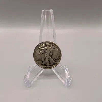 Sale Photo Thumbnail #11: US Walking Liberty silver half dollar coin dated 1944, displayed on a clear acrylic stand.