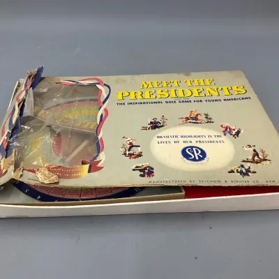 Sale Photo Thumbnail #218: Vintage 1950s 'Meet the Presidents' quiz game by Selchow & Righter, showing significant wear and damage to the box lid.