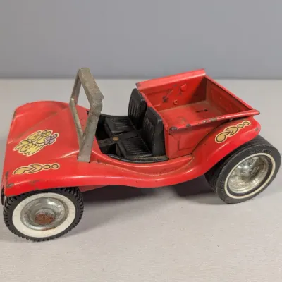 Sale Photo Thumbnail #356: Vintage pressed steel Tonka 'Lil Tom' dune buggy truck in red with psychedelic decals, showing light surface rust and play wear, circa late 1960s to 1970s.