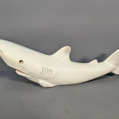 Sale Photo Thumbnail #272: Hand-carved white stone or ceramic shark figurine featuring detailed gill slits and inset glass eyes.
