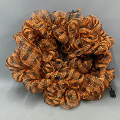 Sale Photo Thumbnail #252: Halloween lighted deco mesh wreath featuring orange and black striped ribbon with integrated string lights and a power plug.