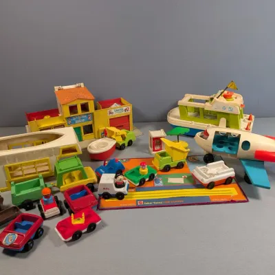 Sale Photo Thumbnail #363: Vintage Fisher-Price Little People playsets and vehicles from the 1970s, including a main street building, airplane, houseboats, and various cars.