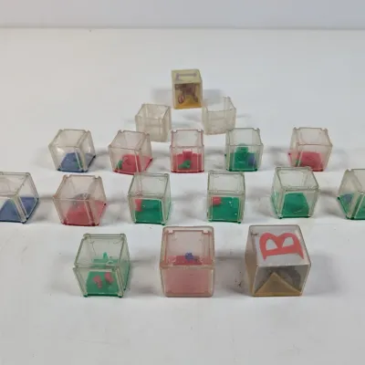 Sale Photo Thumbnail #423: Collection of vintage clear plastic dexterity puzzle cubes with colorful interiors and alphabet letters.