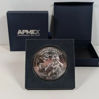 Sale Photo Thumbnail #3: 2021 Tuskegee Airmen America the Beautiful silver coin, displayed in its original APMEX felt mount and presentation box.