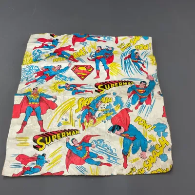 Sale Photo Thumbnail #101: Vintage 1978 Superman comic book style wrapping paper sheet featuring action graphics and logos, showing heavy creasing and edge wear.