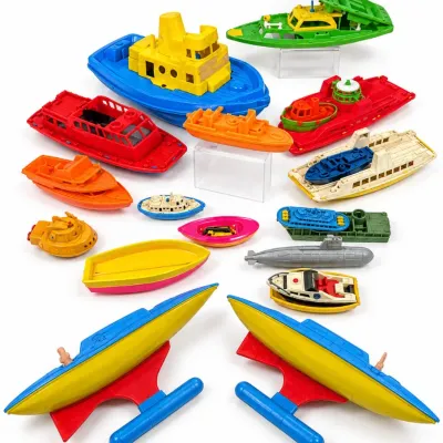 Sale Photo Thumbnail #418: Large collection of vintage colorful plastic toy boats and submarines, featuring various styles including speedboats, tugboats, and hydrofoils.