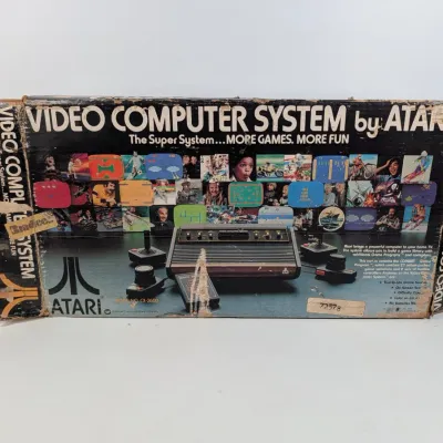 Sale Photo Thumbnail #385: Vintage Atari Video Computer System (CX-2600) original box displaying significant edge wear, tearing, and tape repairs.