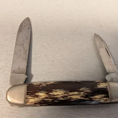 Sale Photo Thumbnail #372: Vintage double-bladed folding pocket knife with faux tortoise shell or stag horn patterned scales and nickel silver bolsters.