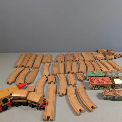 Sale Photo Thumbnail #358: Vintage wooden toy train set featuring track pieces, train cars, and painted building accessories.