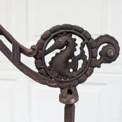 Sale Photo Thumbnail #63: Decorative cast iron element featuring a seahorse design within a medallion detail, showing a weathered dark patina.