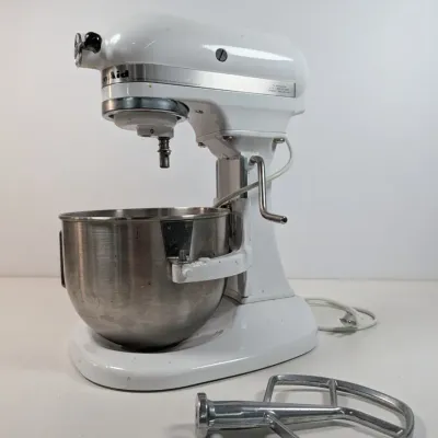 Sale Photo Thumbnail #55: Vintage white KitchenAid bowl-lift stand mixer with a stainless steel mixing bowl and flat beater attachment.