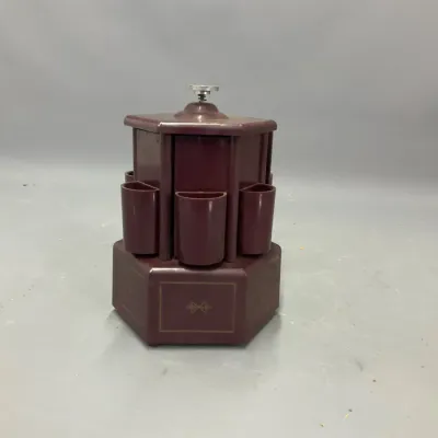 Sale Photo Thumbnail #209: Vintage maroon Bakelite music box cigarette and lipstick dispenser dispenser carousel with gold-tone accents.