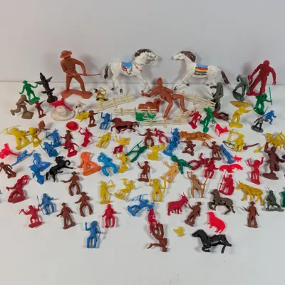 Sale Photo Thumbnail #389: Large assortment of vintage plastic toy figures, including cowboys, Native Americans, horses, and fence pieces in various colors.