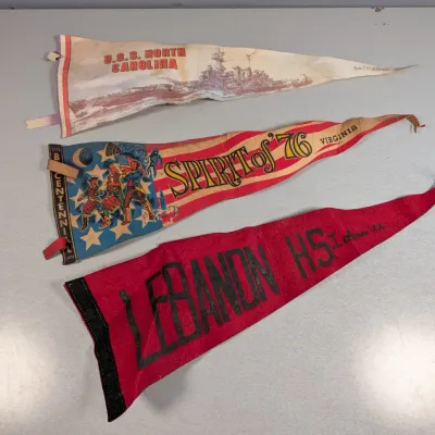 Sale Photo Thumbnail #352: Trio of vintage felt pennants, including a U.S.S. North Carolina souvenir pennant, a 1976 Bicentennial Spirit of '76 Virginia pennant, and a red Lebanon High School pennant.