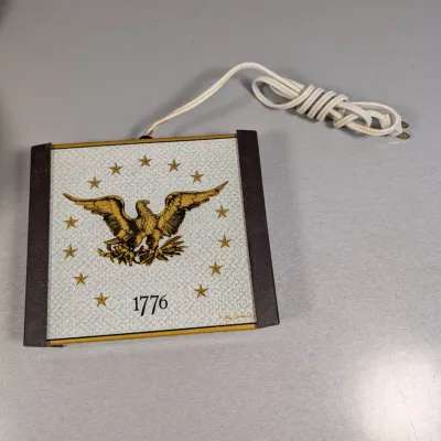 Sale Photo Thumbnail #133: Vintage electric hot plate trivet featuring a Bicentennial American eagle, stars, and 1776 motif.