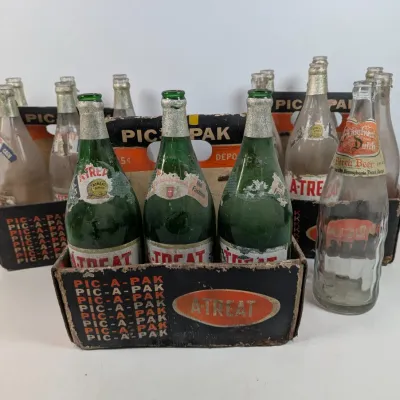 Sale Photo Thumbnail #45: Collection of vintage A-Treat and Pennsylvania Dutch soda bottles with original cardboard Pic-A-Pak six-pack carriers showing heavy wear and age.