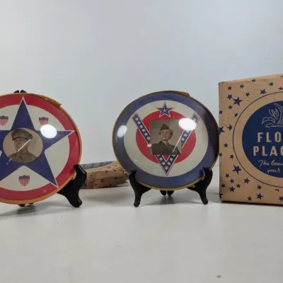 Sale Photo Thumbnail #79: Pair of vintage World War II era patriotic glass picture plaques with military portraits, displayed on black stands with original box.