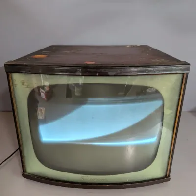Sale Photo Thumbnail #332: Vintage Emerson tabletop television in a dark wood cabinet, showing wear and age consistent with mid-20th-century production.