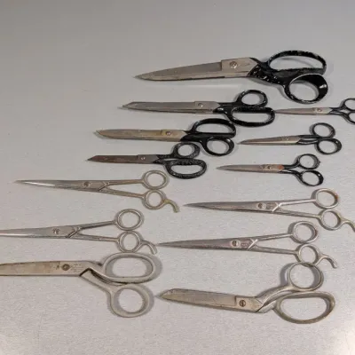 Sale Photo Thumbnail #162: Collection of vintage sewing, tailoring, and barber scissors in various sizes and styles, showing age-appropriate wear and patina.