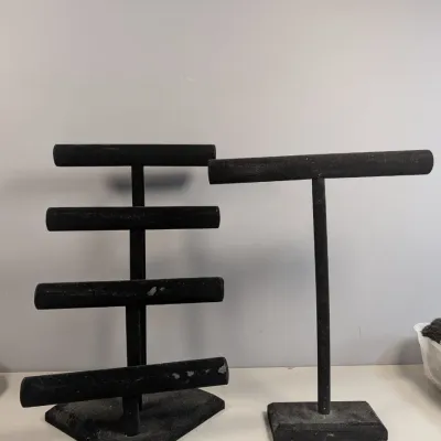 Sale Photo Thumbnail #174: Two black velvet T-bar jewelry display stands, including a four-tier rack and a single taller stand.