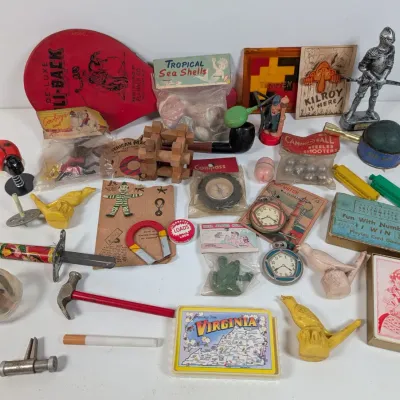 Sale Photo Thumbnail #386: Collection of vintage mid-century novelty items, small toys, games, and trinkets, including a Hi-Li-Back paddle, knight figurine, and bird whistles.