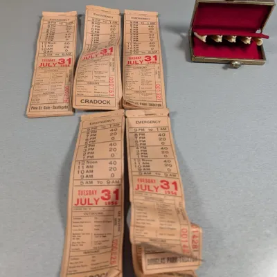 Sale Photo Thumbnail #374: Collection of vintage bus transfers dated July 31, 1956, alongside a small red velvet-lined metal coin purse.
