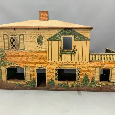 Sale Photo Thumbnail #276: Vintage lithographed tin or wood dollhouse featuring detailed brick and shutter exterior graphics with a faux chimney and balcony detail.
