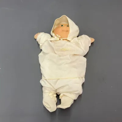 Sale Photo Thumbnail #245: Vintage Cabbage Patch Kids baby doll wearing a cream-colored outfit with a bonnet and booty ties, circa 1980s.