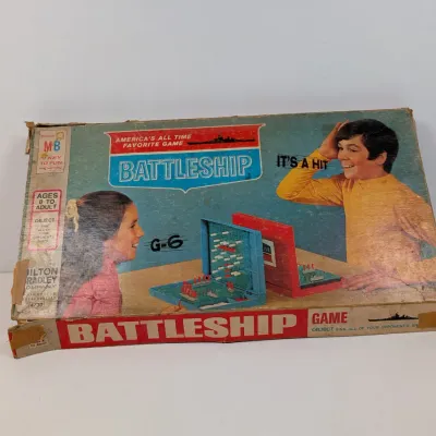 Sale Photo Thumbnail #432: Vintage 1960s Milton Bradley Battleship board game in its original box, showing edge wear, corner scuffs, and taped repairs.