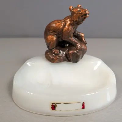 Sale Photo Thumbnail #27: Vintage white slag glass or marble tray topped with a metal figurine of a bear on a rock.
